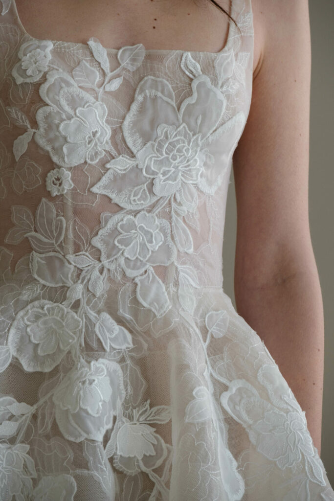 Sheer lace dress with floral appliqué details.