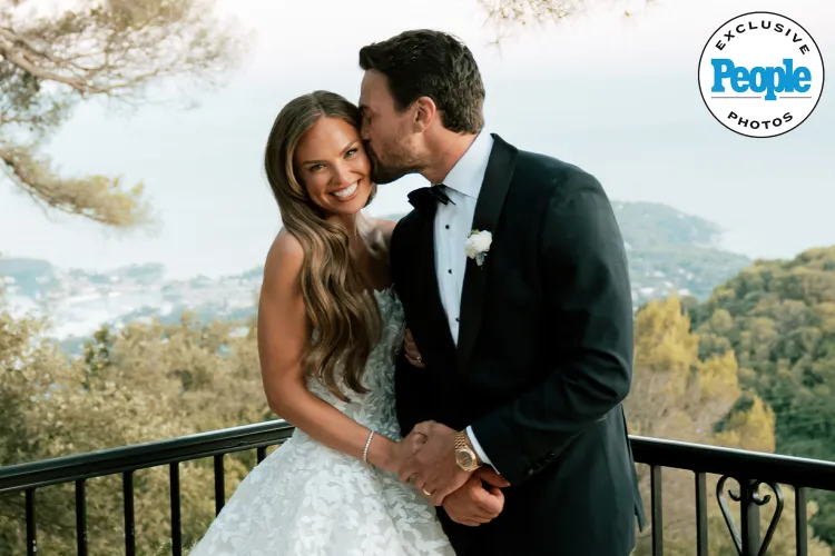 Bride smiles as groom kisses her forehead.