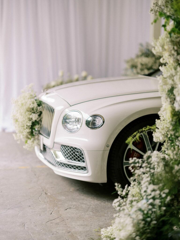 Bride Katya Ruiz by decorated white luxury car.