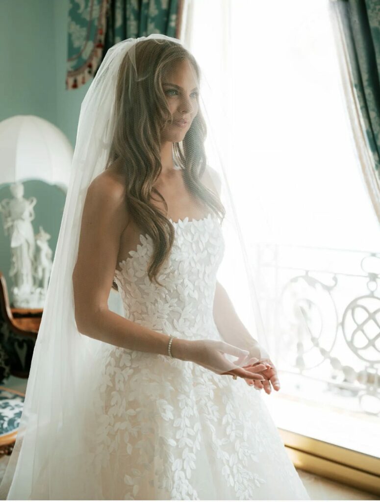 Bride in strapless lace gown, softly lit.