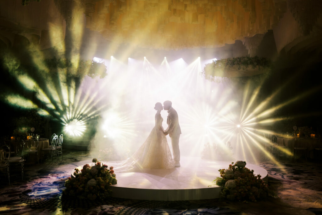Bride Katya Ruiz poses in floral-lit venue.