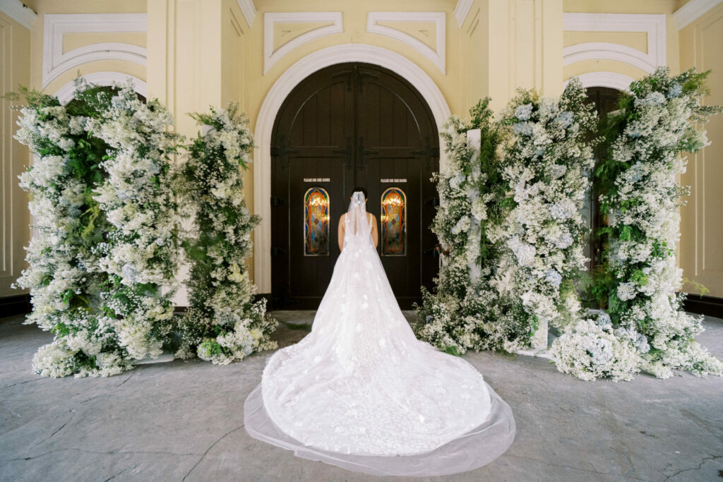 Bride Katya Ruiz in couture gown, floral backdrop.