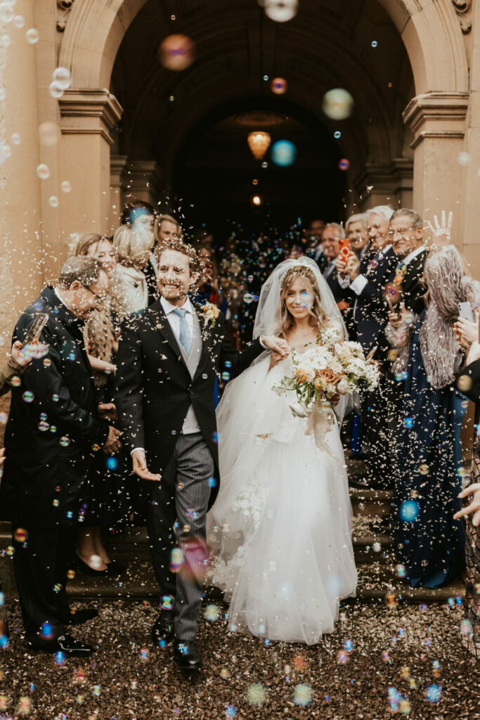 Newlyweds exit amid bubbles and confetti.