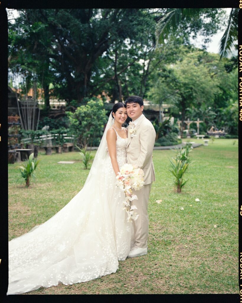 Bride and groom smiling in garden.