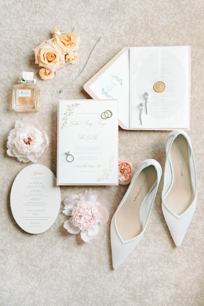 Luxury bridal items arranged on beige fabric.