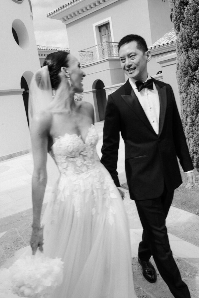 Katya Ruiz and groom walk hand in hand, smiling.