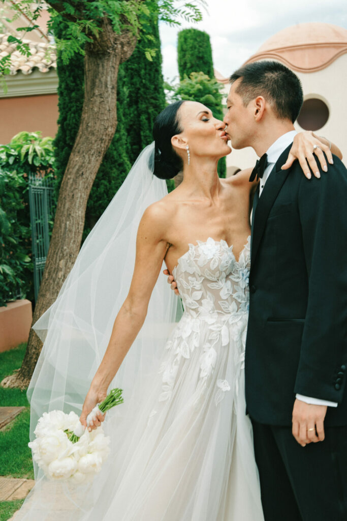 Katya Ruiz kisses groom in couture gown outdoors.