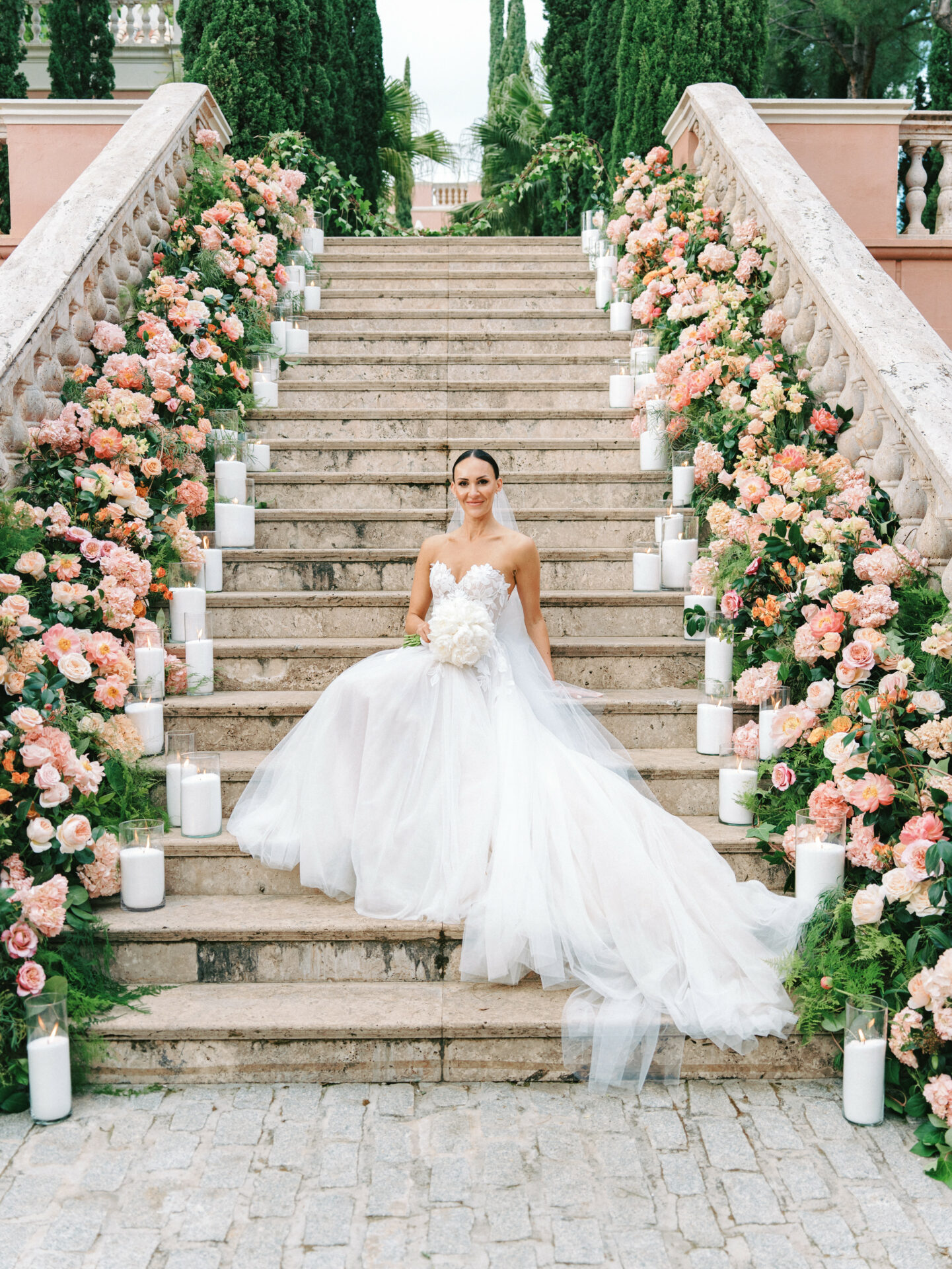 Bride in Mira Zwillinger gown on floral steps.