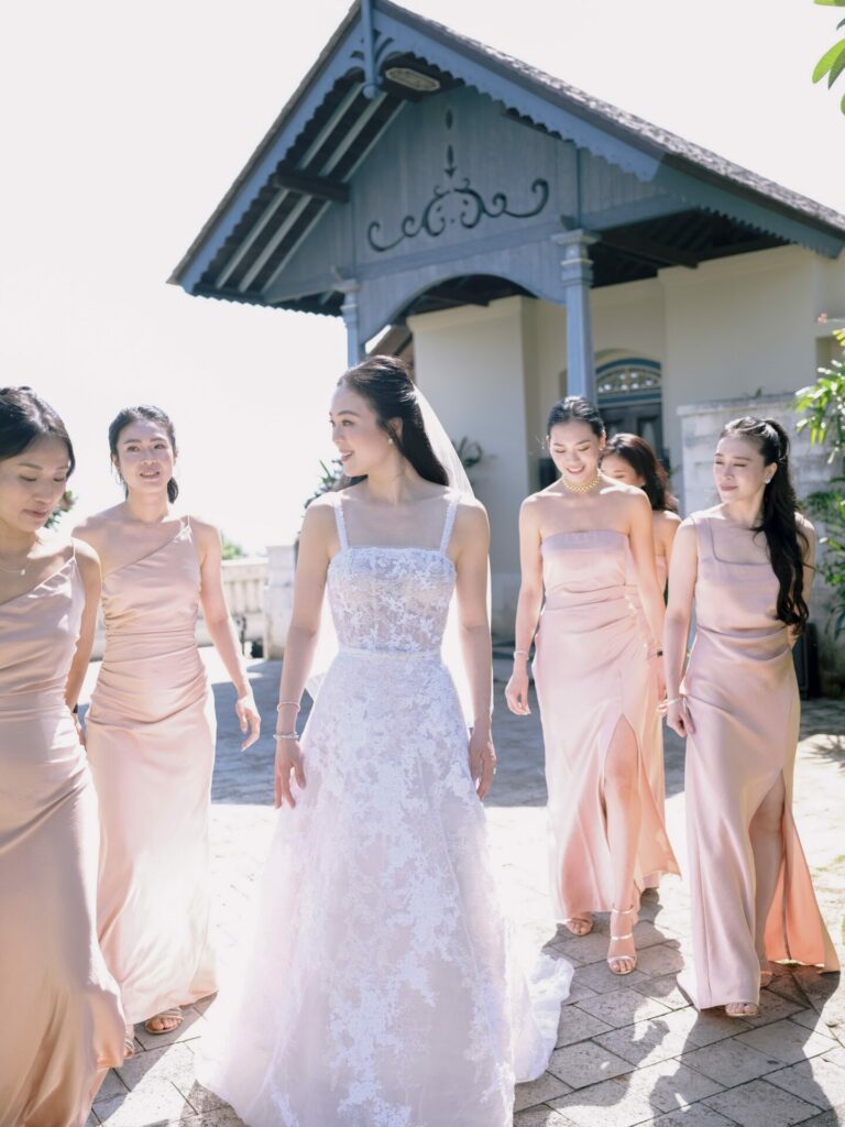 Bride and five bridesmaids smiling outdoors.