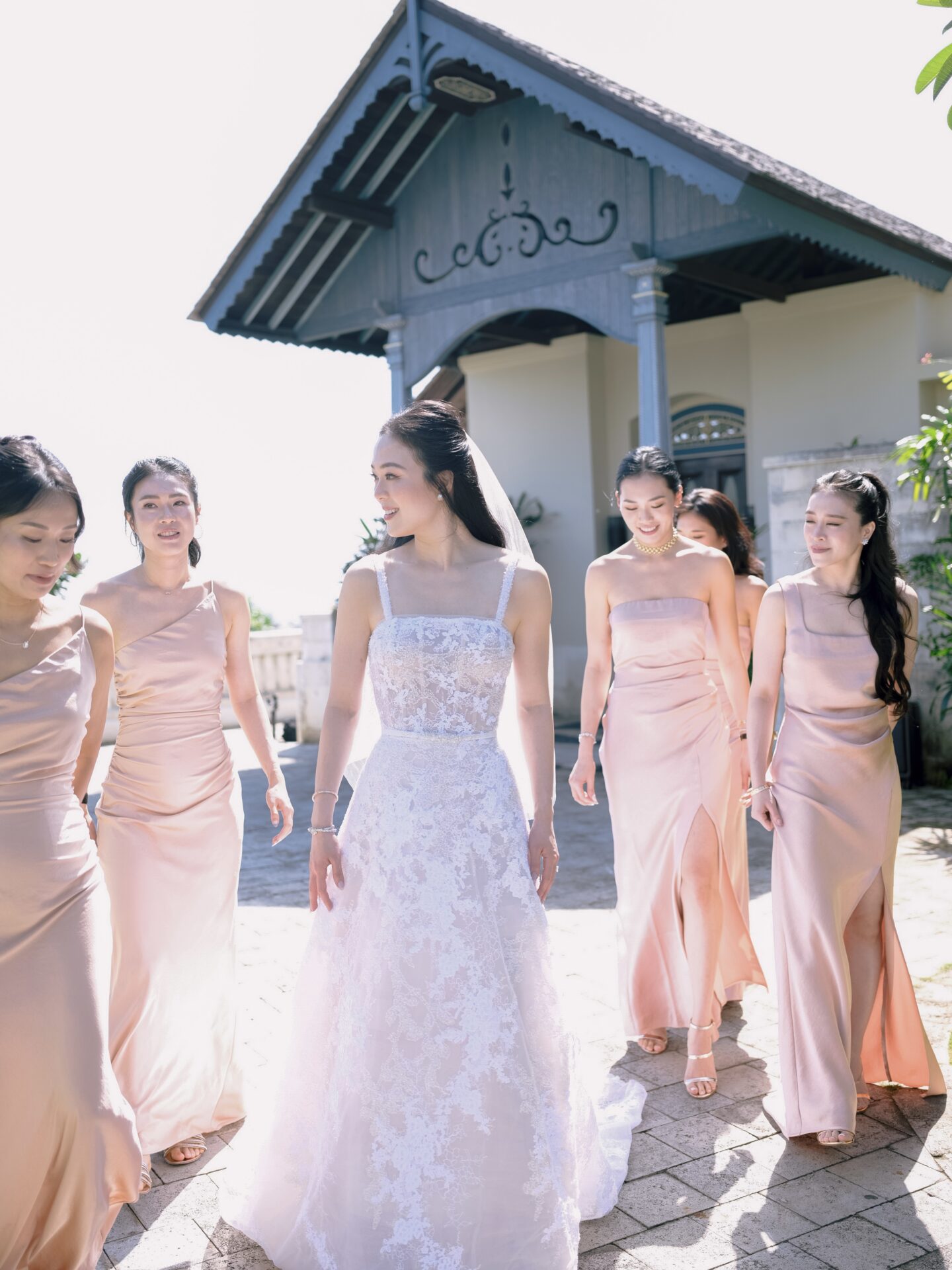 Bride and five bridesmaids smiling outdoors.