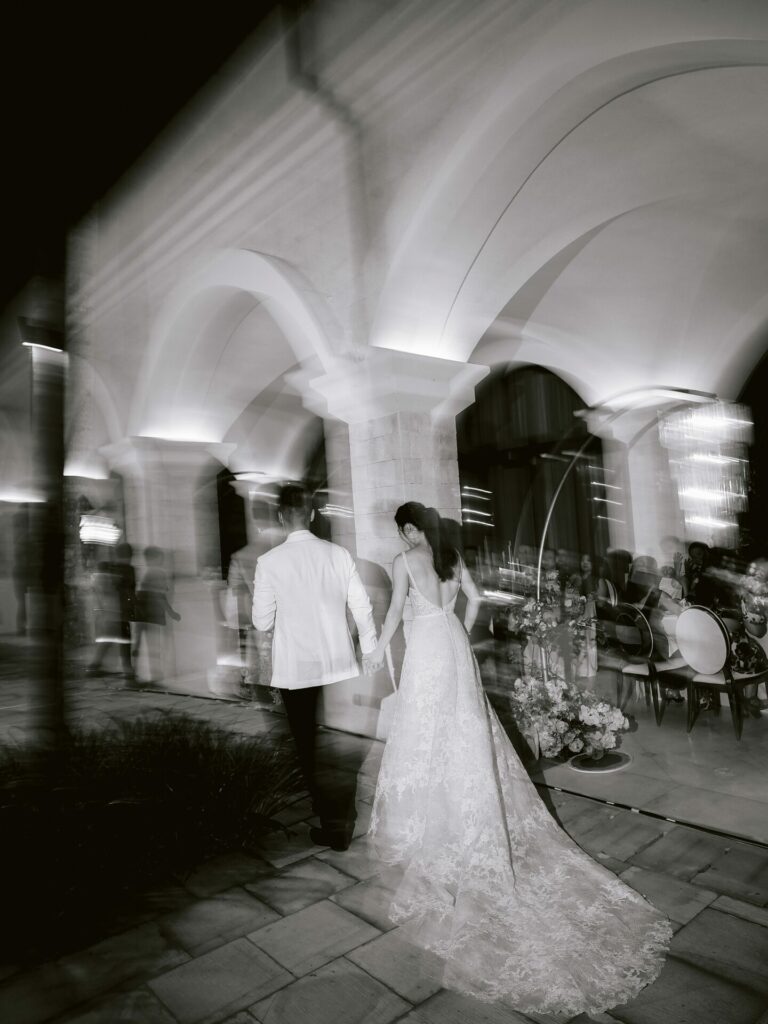 Bride and groom walk through elegant venue.