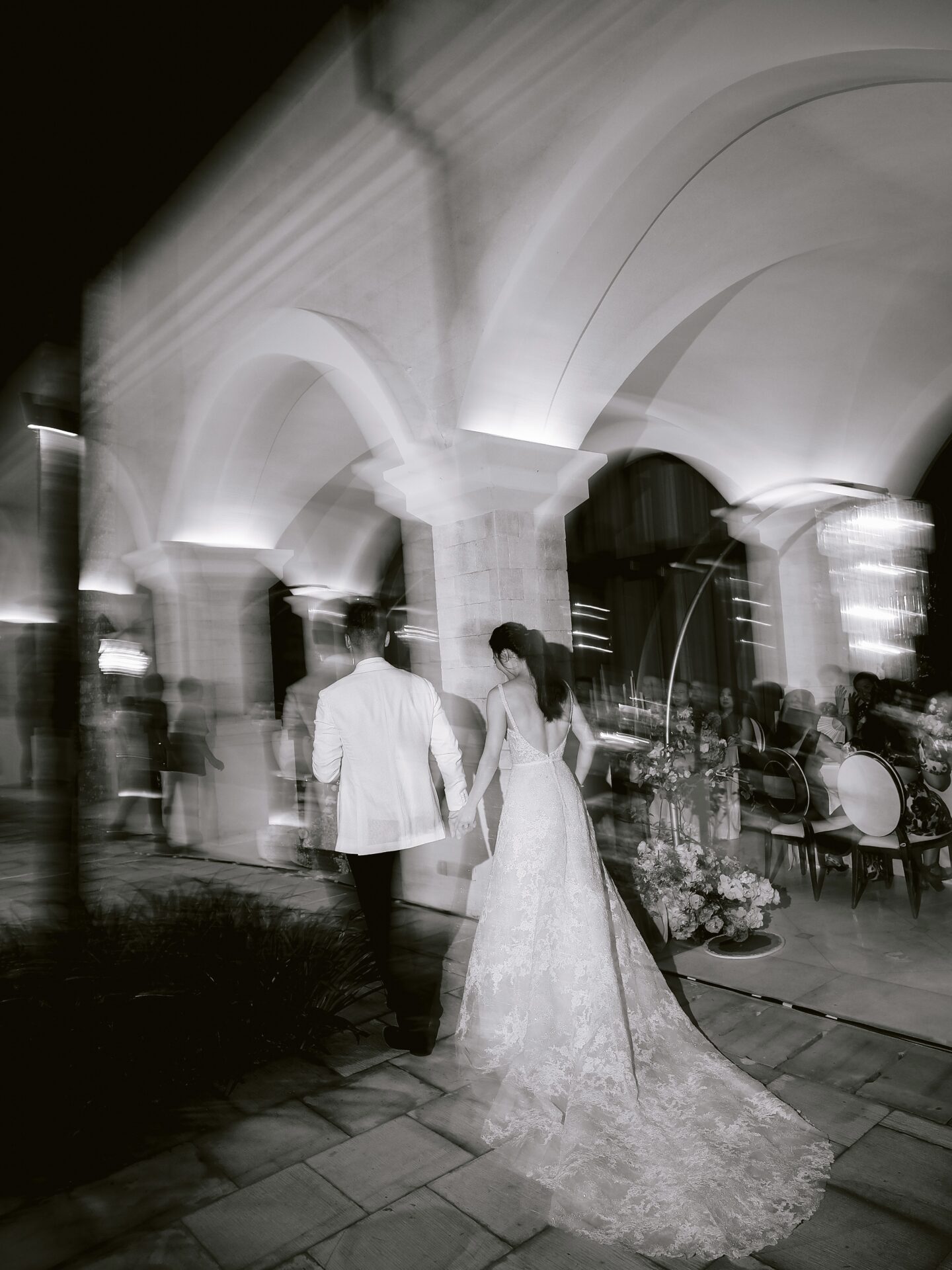 Bride and groom walk through elegant venue.
