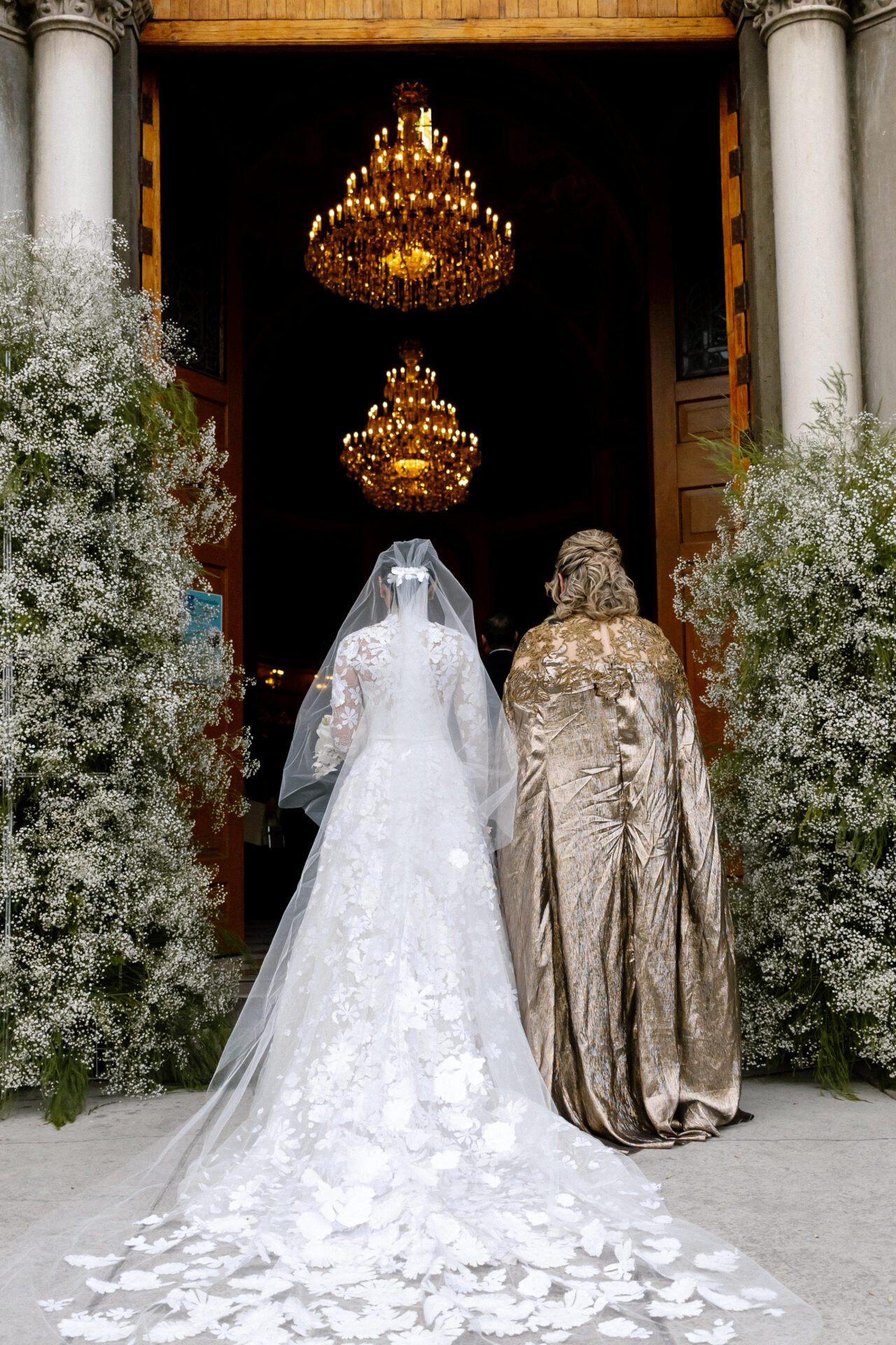 Bride and companion enter grand, petal-strewn entrance.