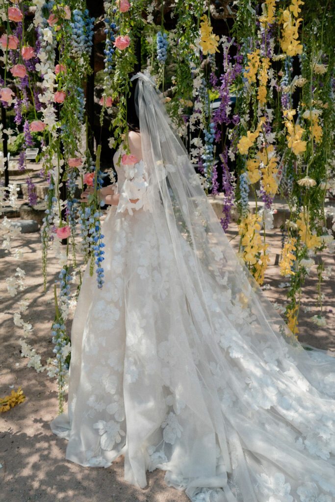 Bride Katya Ruiz in floral gown, garden blooms.