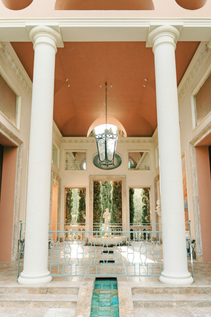Elegant courtyard with columns, lantern, fountain, and statue.