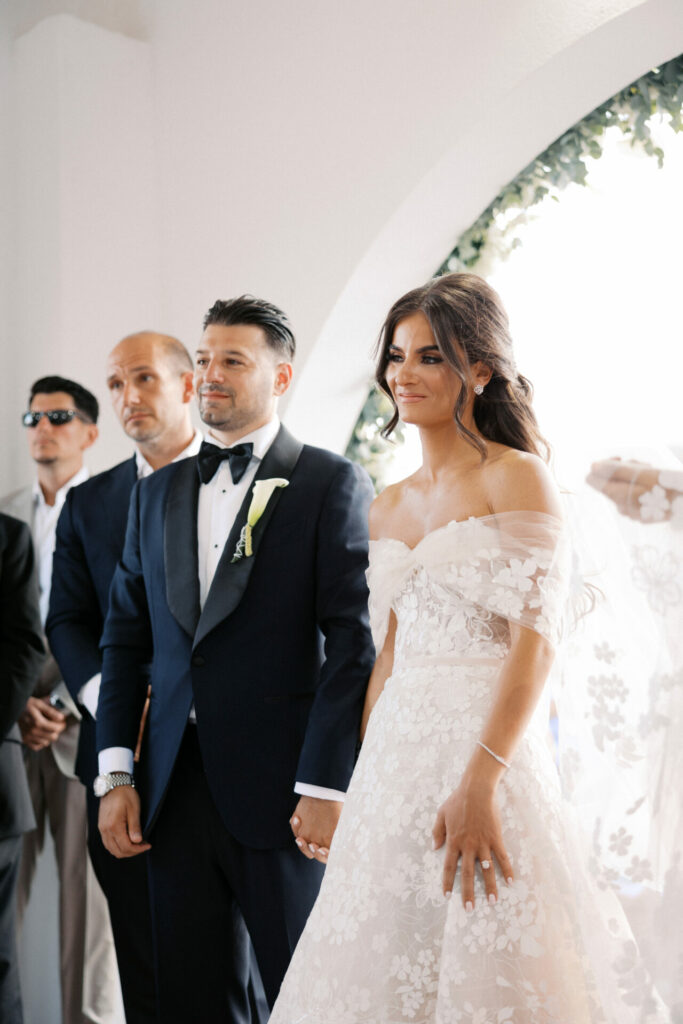 Katya Ruiz weds in couture gown, holding groom’s hand.