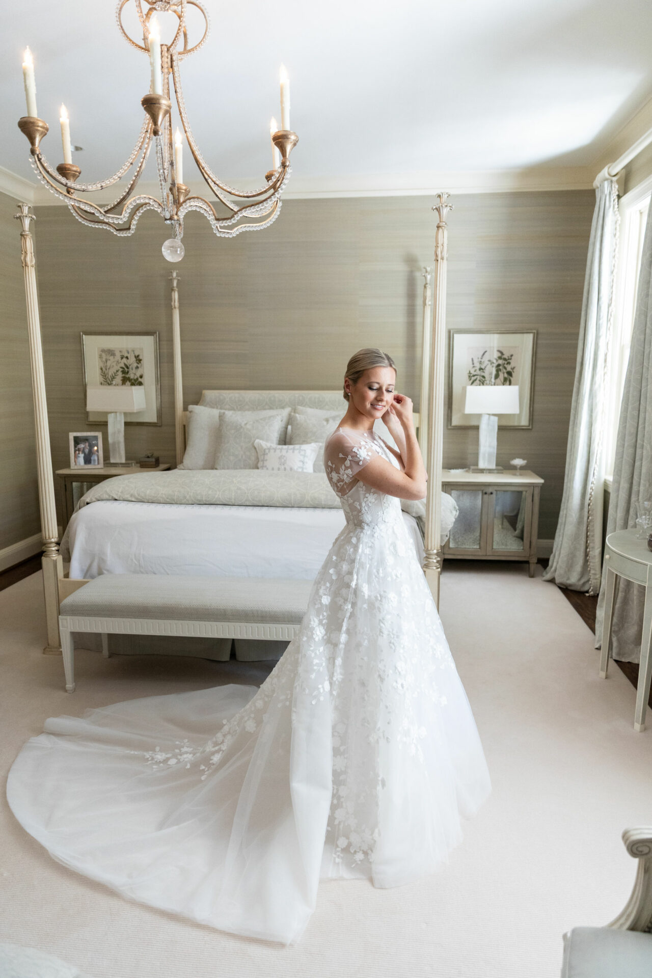 Smiling bride in lace dress in elegant bedroom.