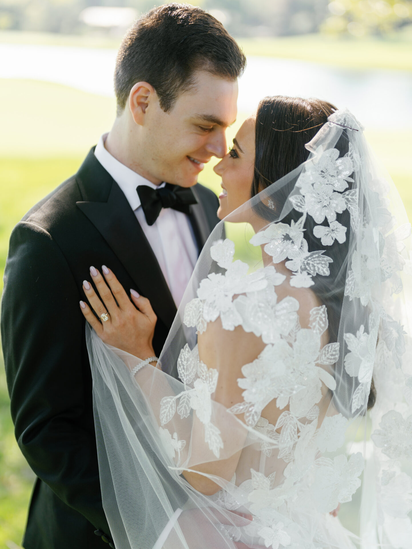 Bride and groom outdoors, smiling at each other.