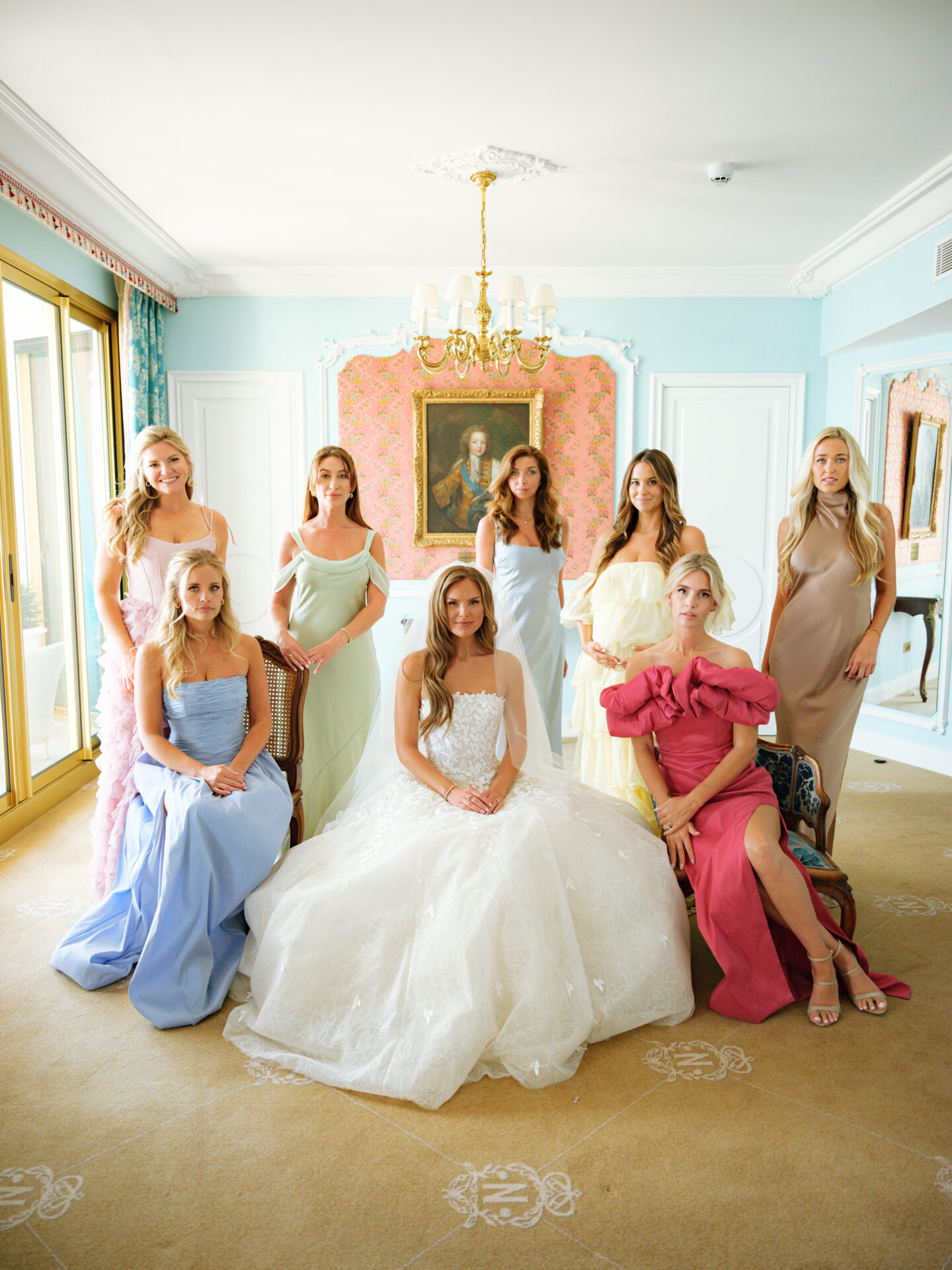 Bride with seven bridesmaids in elegant, ornate room.