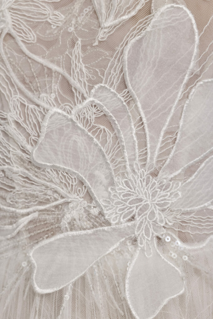 White floral embroidery with sequins on sheer fabric.