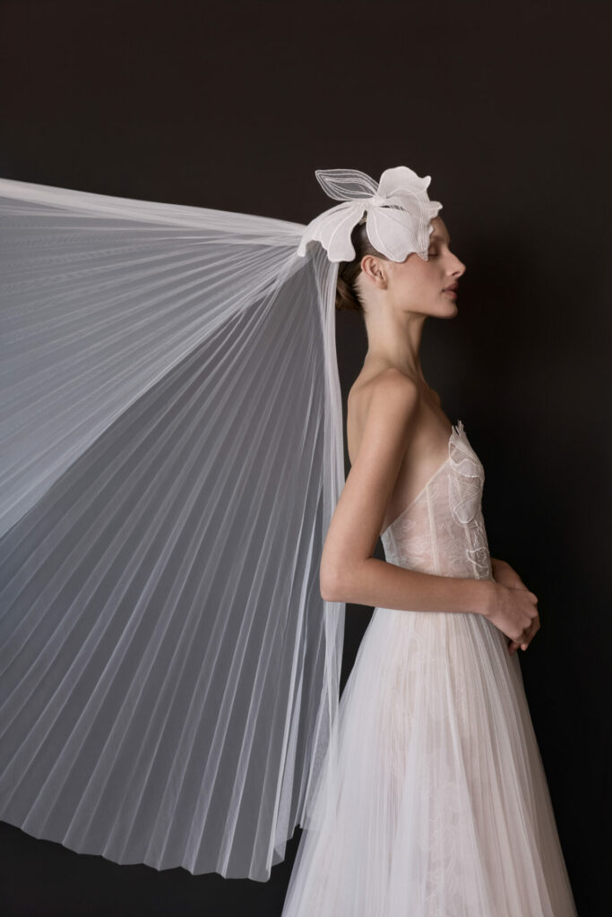 Bride in sheer gown and veil, in profile.