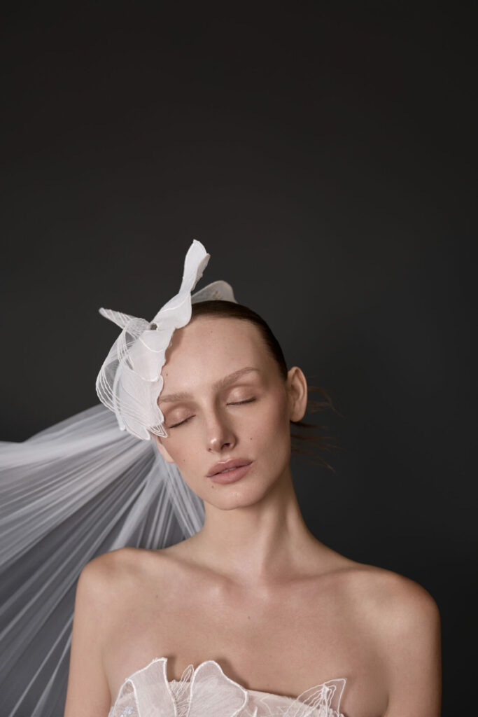 Woman with white headpiece, eyes closed, serene.