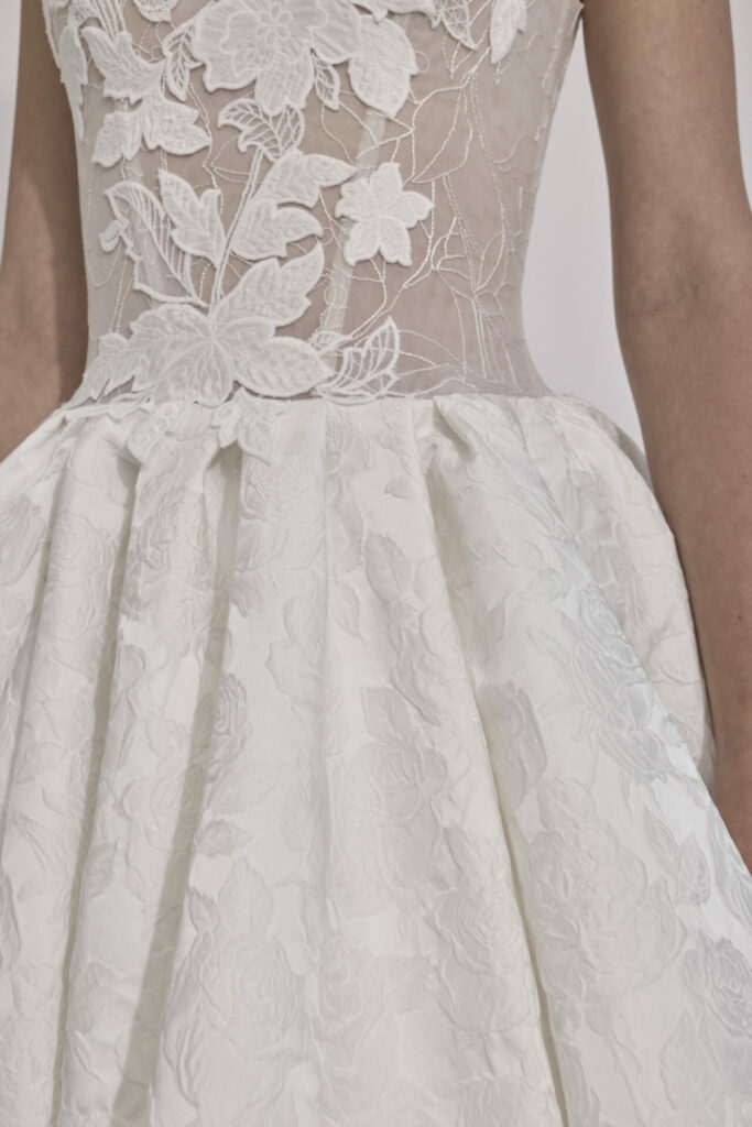 White dress with sheer lace bodice and floral skirt.