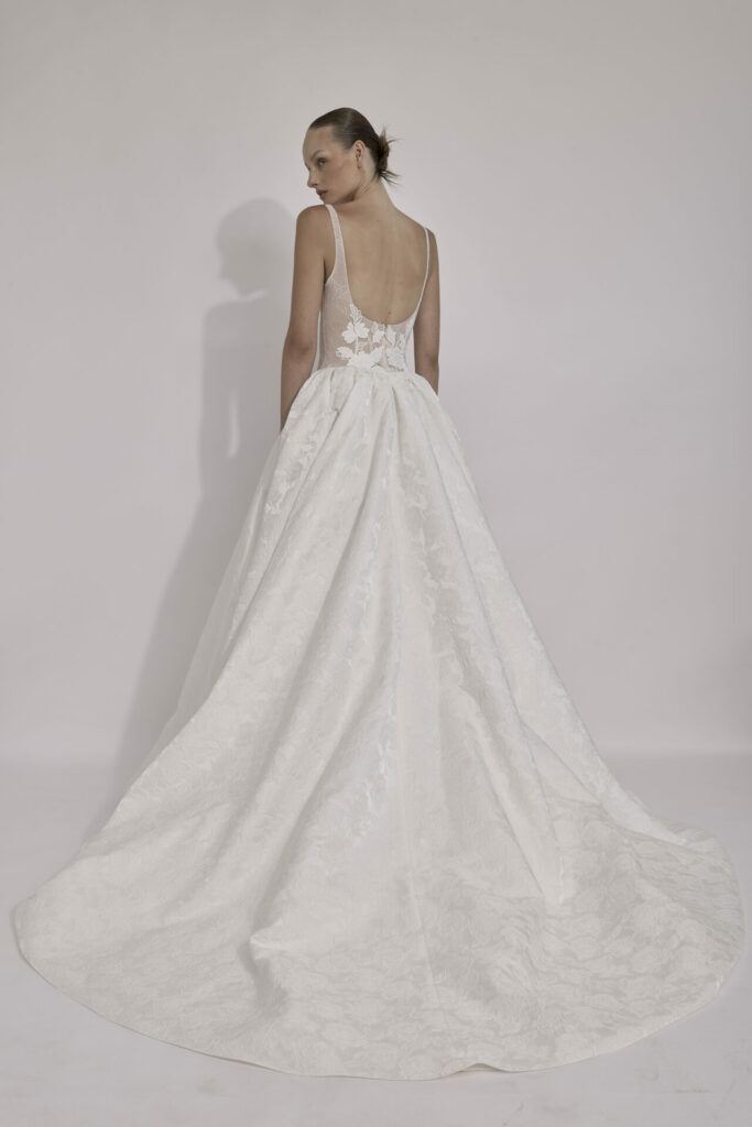 Woman in floral white gown seen from behind.