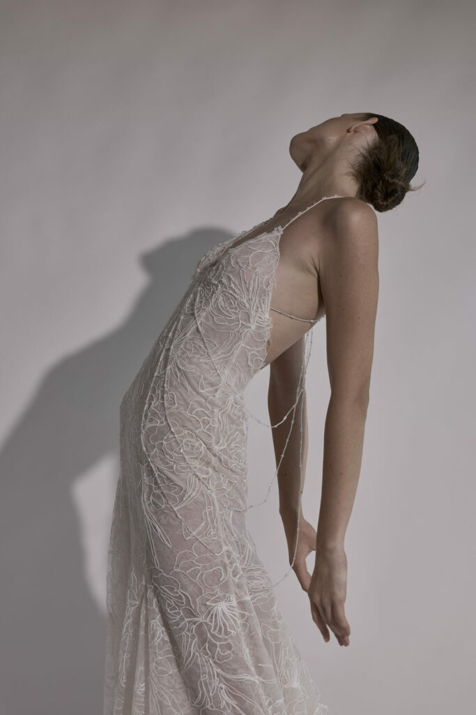 Woman in sheer floral dress poses dramatically.