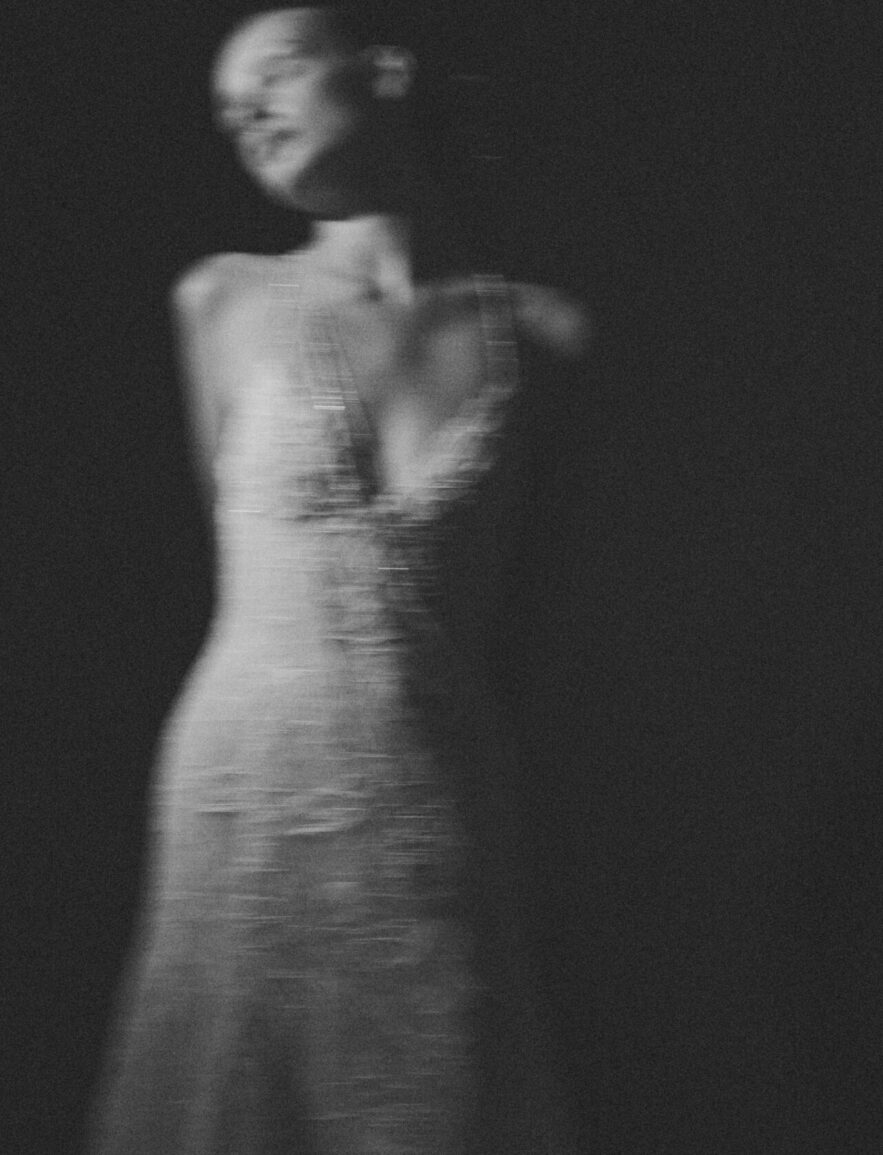 Blurry black-and-white figure in sleeveless dress, dreamy.