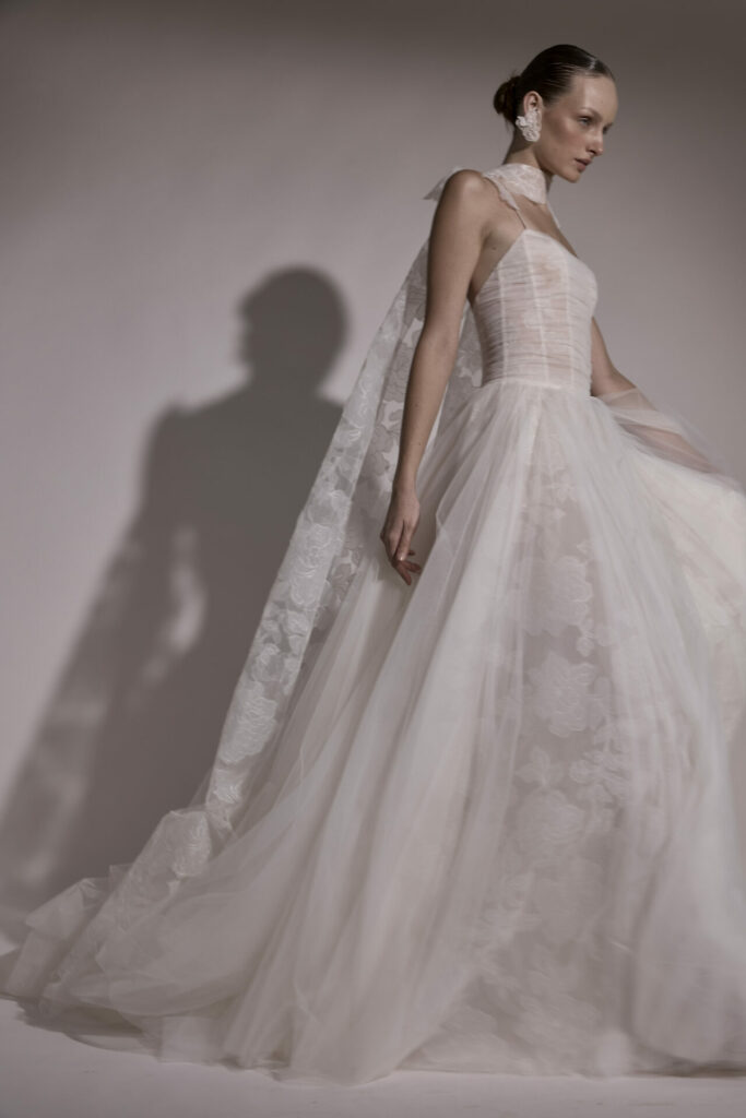Woman in sheer strapless wedding gown with train.