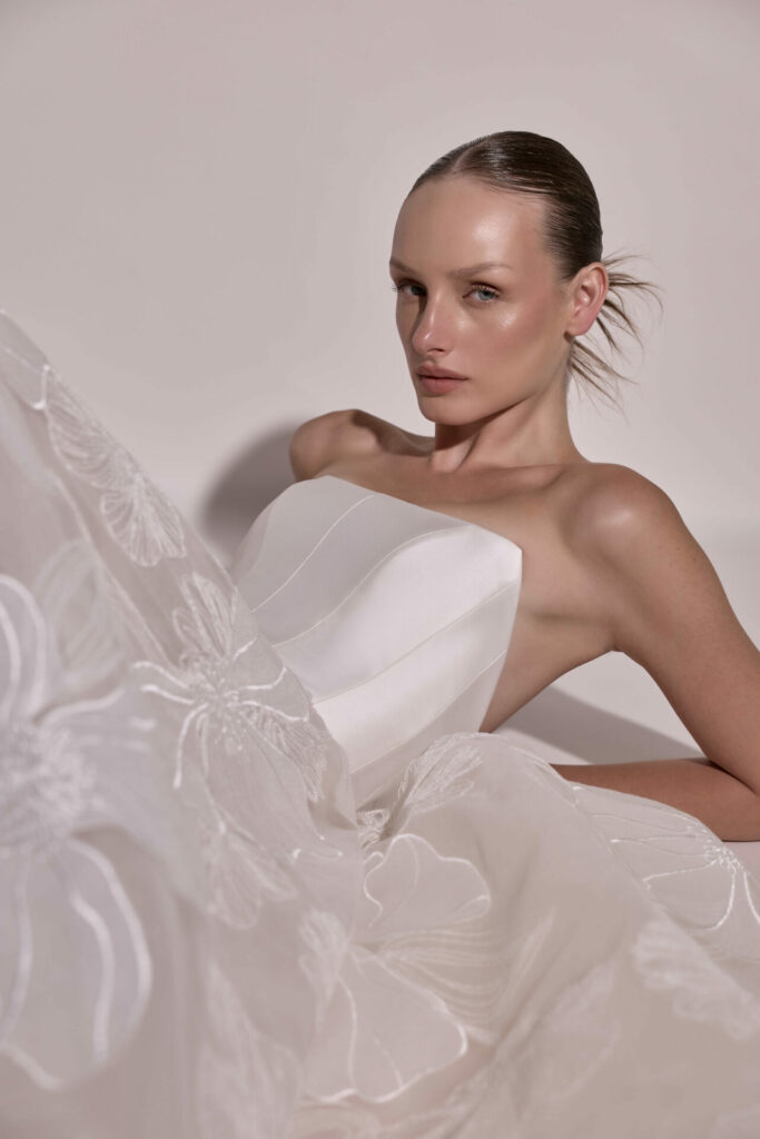 Bride with sleek hair in floral strapless gown.