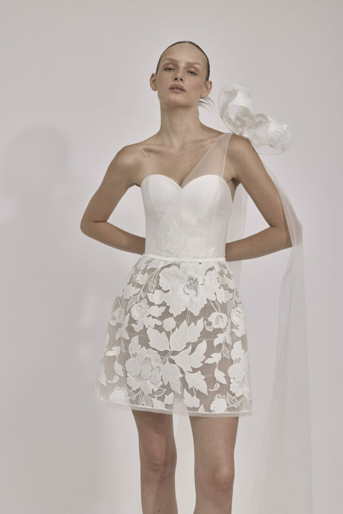 Woman in white lace mini dress with bow.