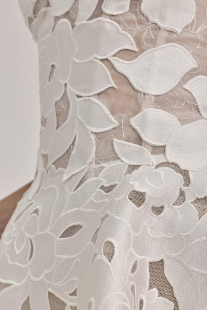 Sheer mesh with large white floral embroidery.