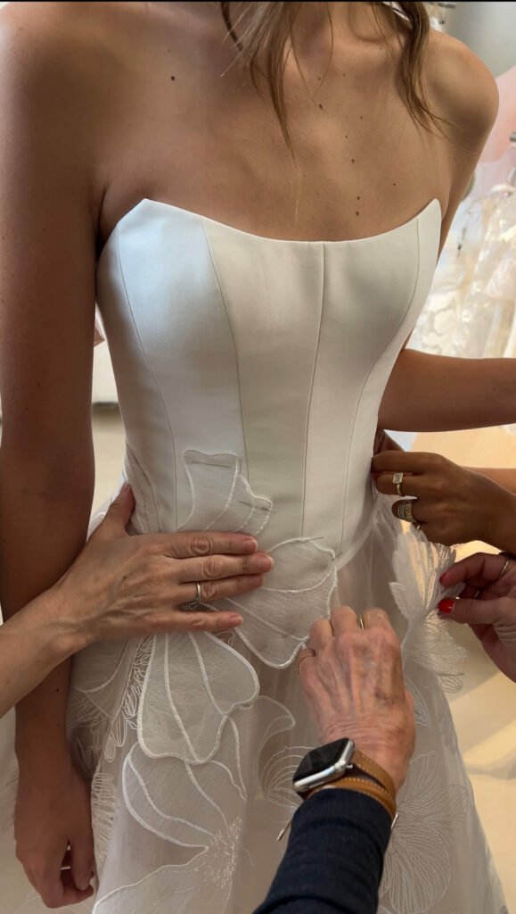 Woman in strapless wedding dress, three adjust details.