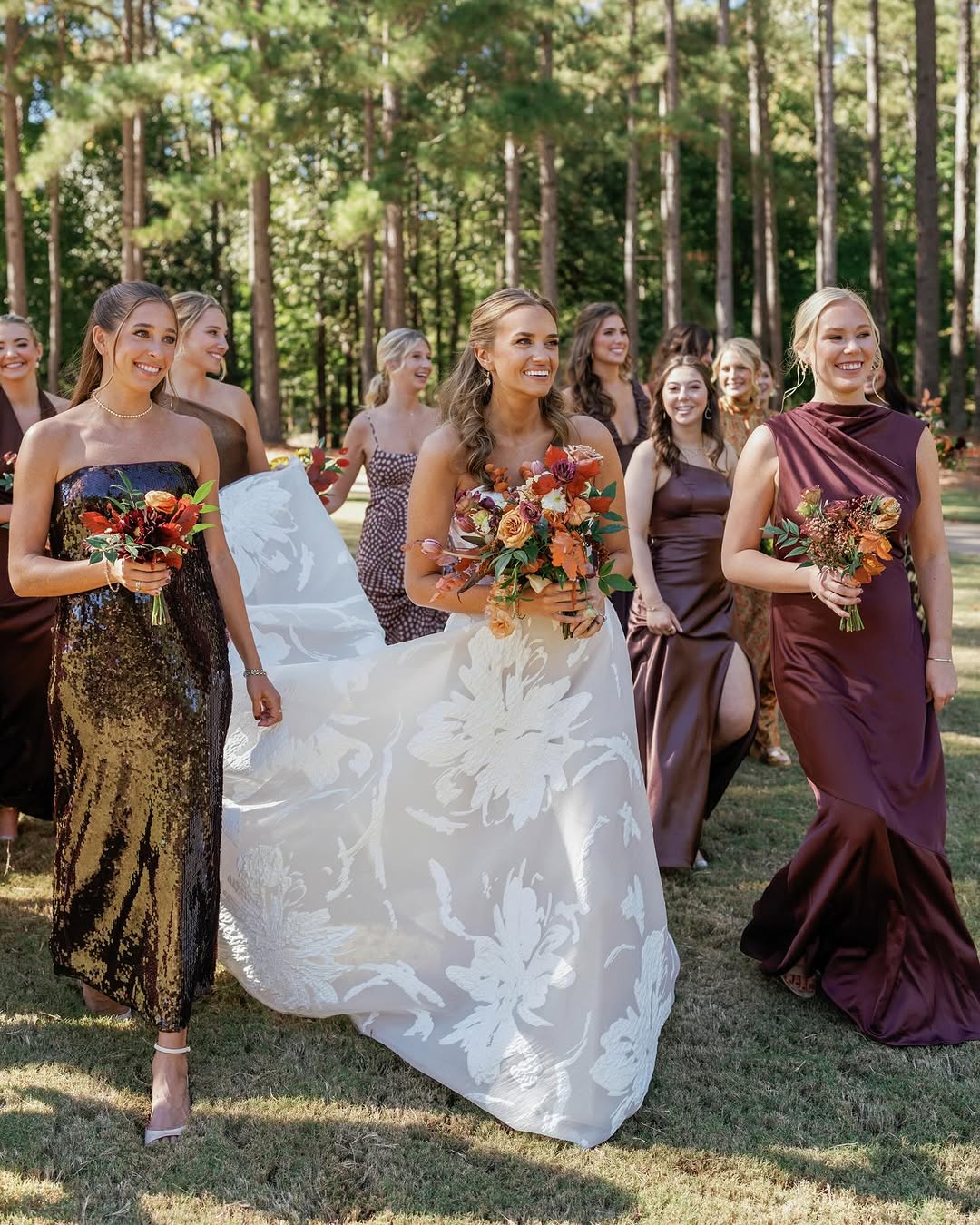 Bride in Mira Zwillinger Amy gown outdoors with joyful bridesmaids.