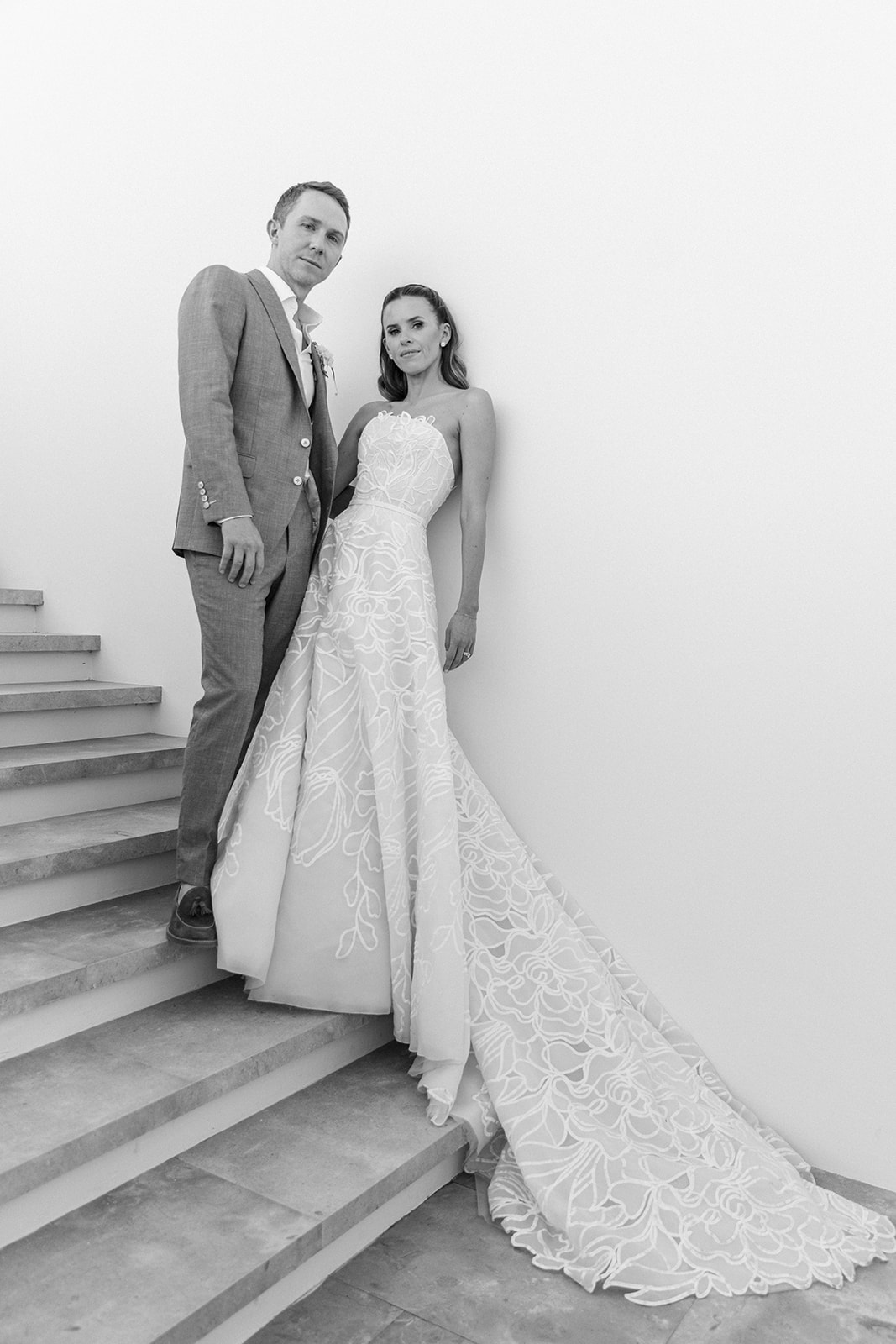 Bride and groom on stairs in black and white.