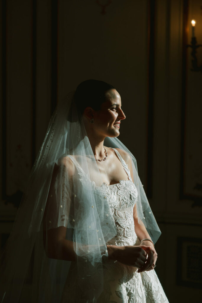 Katya Ruiz in lace Mira Zwillinger gown, smiling gently.
