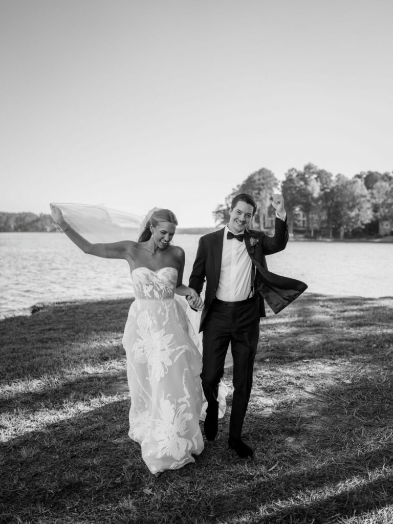Bride Katya Ruiz and groom laugh, walking lakeside.