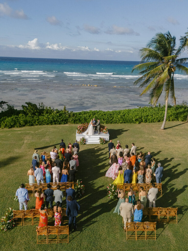 Bride and groom on stage at oceanfront wedding.