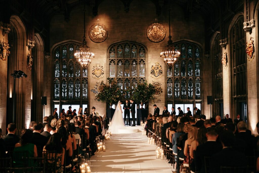 Bride and groom at altar in ornate hall, candles glowing.
