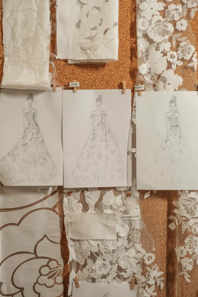 Fashion sketches on board with lace and floral fabrics.