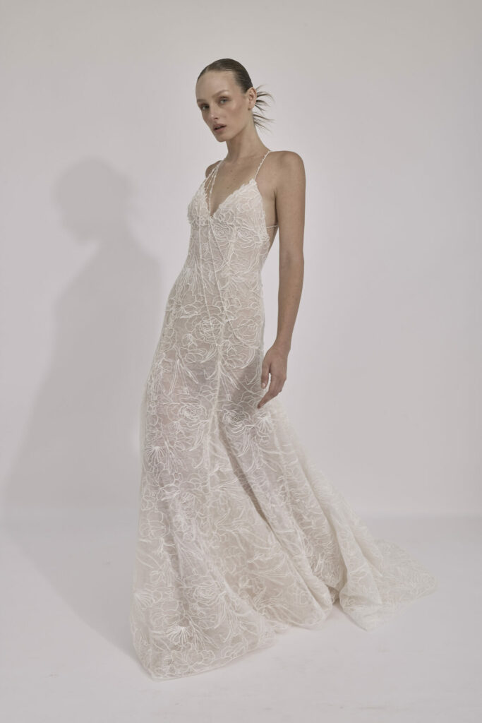 Woman in white lace gown with deep V-neckline.