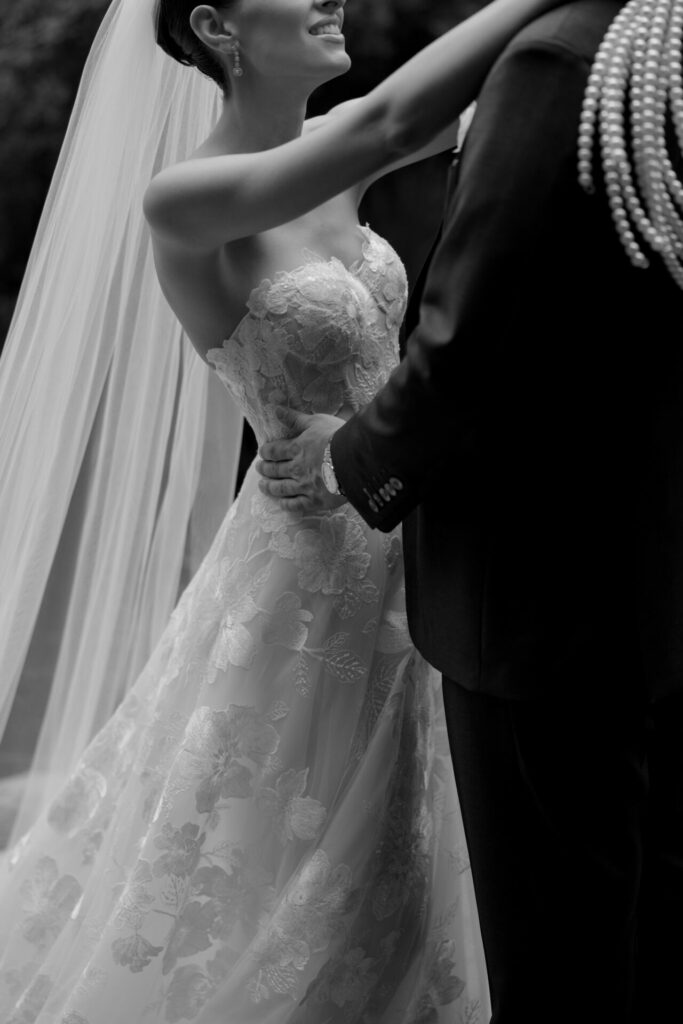 Bride Katya Ruiz joyfully embraces in elegant gown.