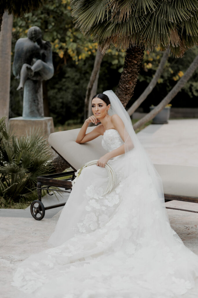 Katya Ruiz poses in strapless gown with veil and flowers.
