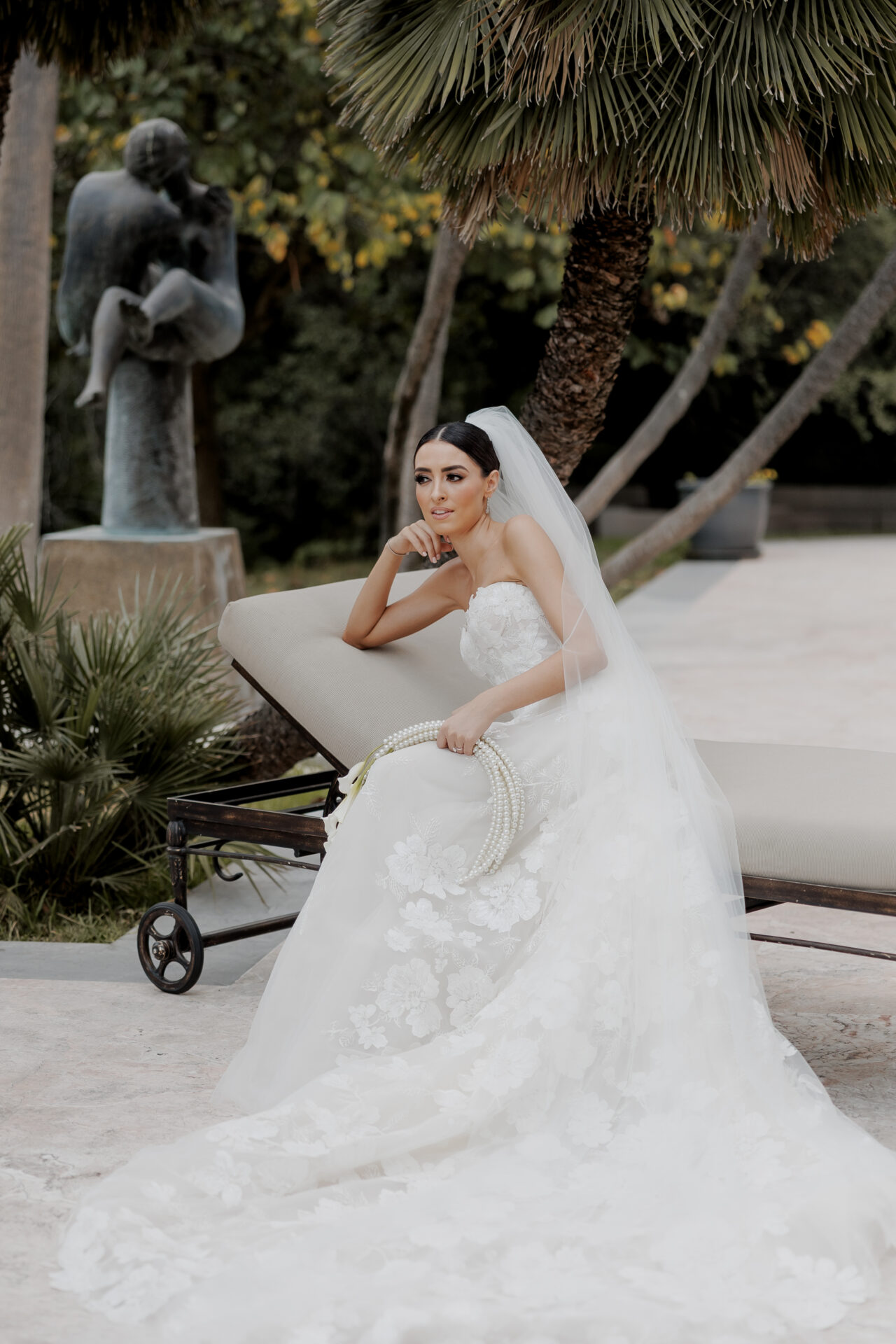 Katya Ruiz poses in strapless gown with veil and flowers.