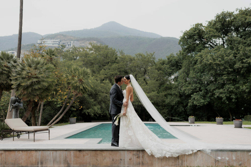 Bride Katya Ruiz kisses groom by a pool.