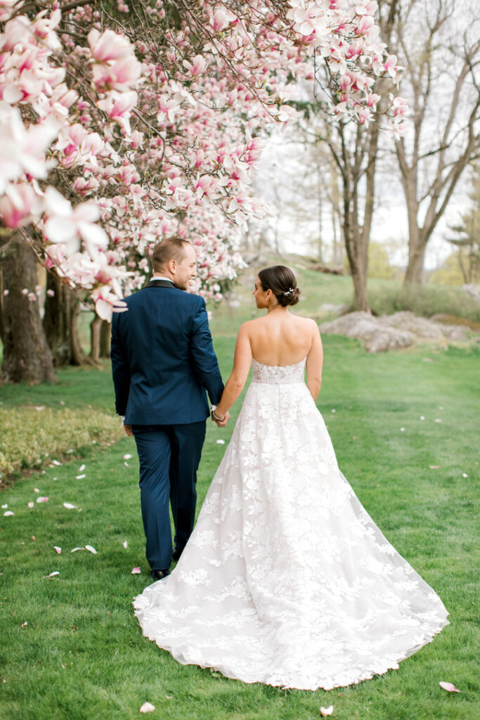 Couple holding hands, woman in trendy A-line gown.