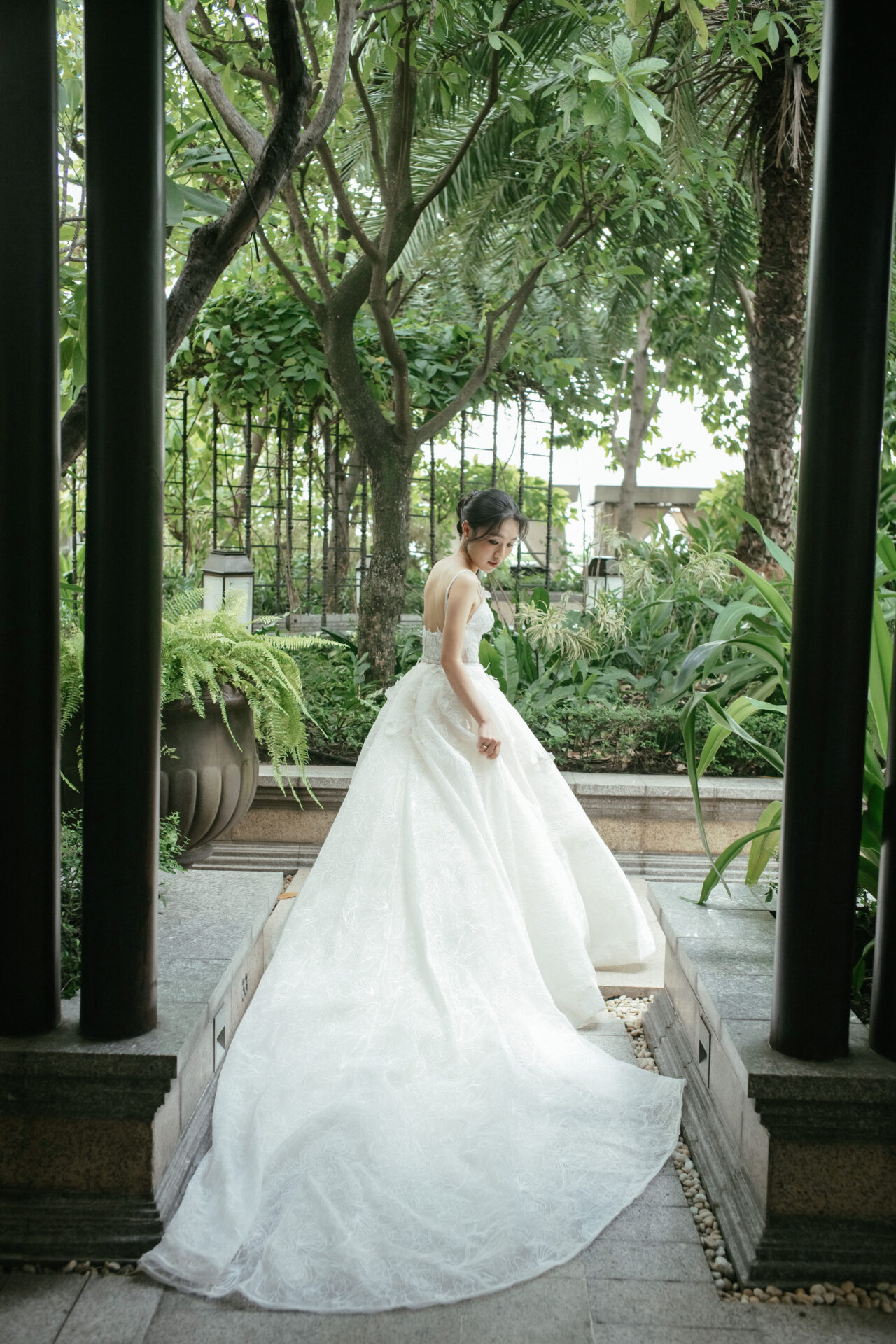 Katya Ruiz in couture gown, serene in lush garden.