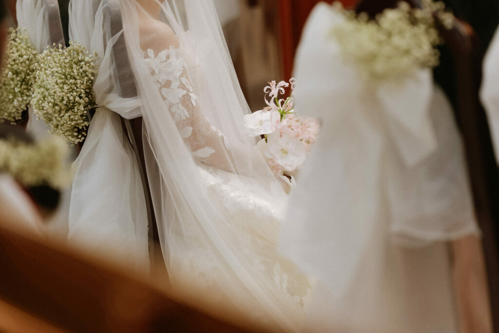 Katya Ruiz in Mira Zwillinger gown holding pink-white bouquet.